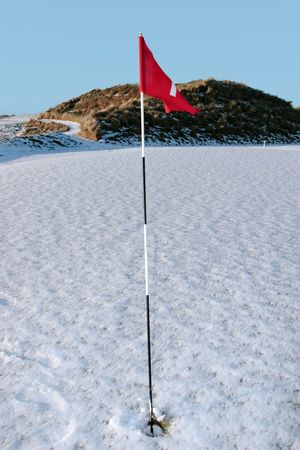 flag on a snow covered links golf course in ireland in winterの写真素材
