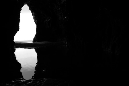 a view from the inside of a beach cave looking out at the seaの写真素材