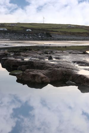 rock pool on beale beach co kerry ireland on a cold winters morning with turbine in the backgroundの写真素材