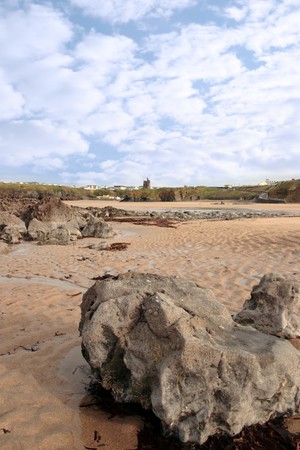 a rocky beach with castle on a warm day with a calm sea an ideal place to have a walk in irelandの写真素材