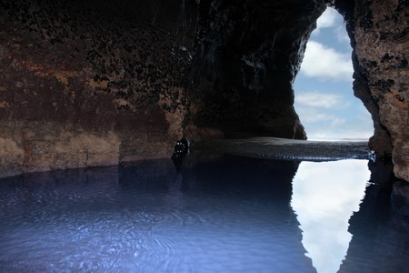 a view from the inside of a beach cave looking out at the seaの写真素材