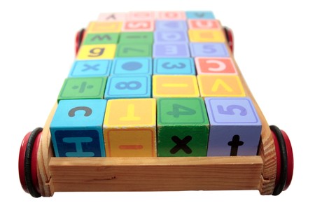 childrens toy letter building blocks all together in a toy cart isolated on white backgroundの写真素材