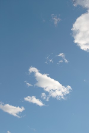 white puffy clouds in a blue skyの写真素材