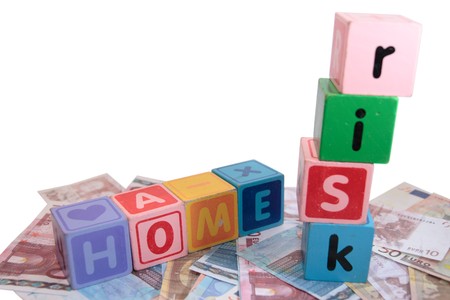 assorted childrens toy letter building blocks against a white background on money that spell home riskの写真素材