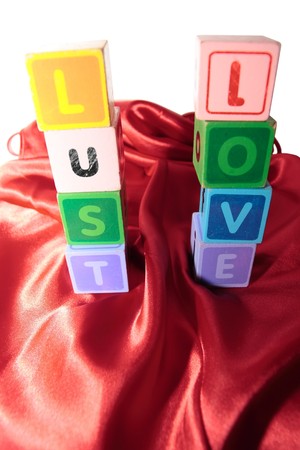 lust and love written with blocks on a silk nightie against white backgroundの写真素材