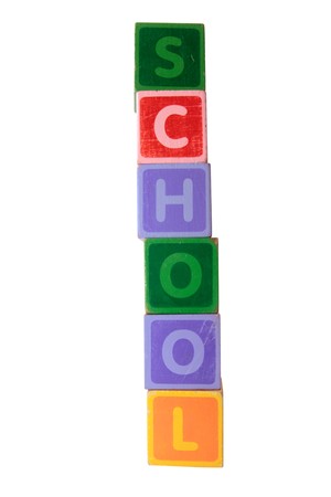 assorted childrens toy letter building blocks against a white background that spell school の写真素材