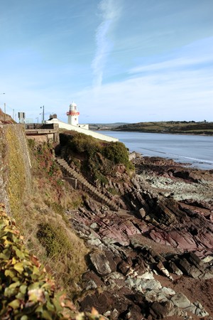 lighthouse during a sunny day on the rocks in with steps to beach in youghal county cork irelandの写真素材