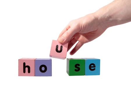 toy letters that spell house against a white background  