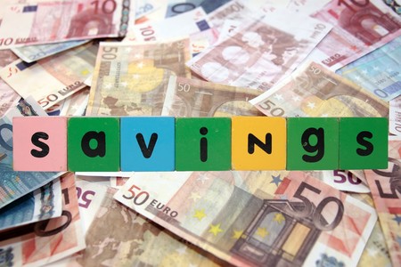toy letters that savings against a money background の写真素材