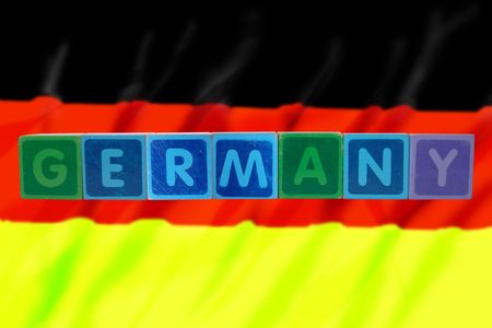 toy letters that spell germany against a flag backgroundの写真素材