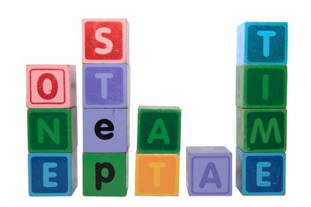 toy letters that spell one step at a time against a white background の写真素材