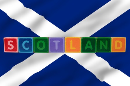 toy letters that spell scotland against a flag background の写真素材