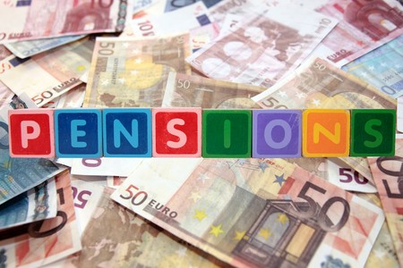 toy letters that spell pensions against a cash backgroundの写真素材