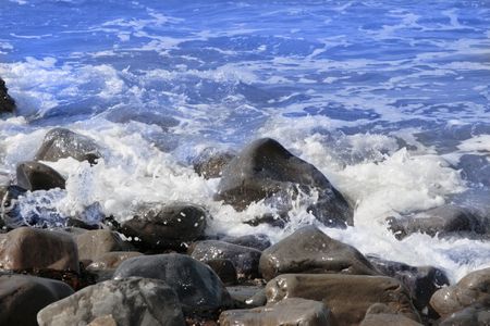 a pebbled beach on a warm day with a calm sea as a backgroundの写真素材