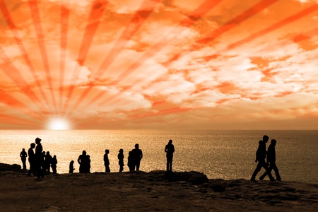 Silhouette of crowd of people on the edge of a cliff in irelandの写真素材
