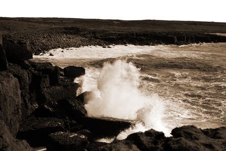 cliffs and coastline of the burren in county clare ireland with giant waves crashing on the rocks in sepiaの写真素材