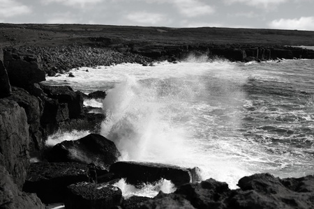 cliffs and coastline of the burren in county clare ireland with giant waves crashing on the rocks in black and whiteの写真素材