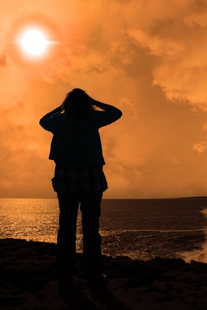 a lone woman looking sadly over the cliffs edge in county clare irelandの写真素材