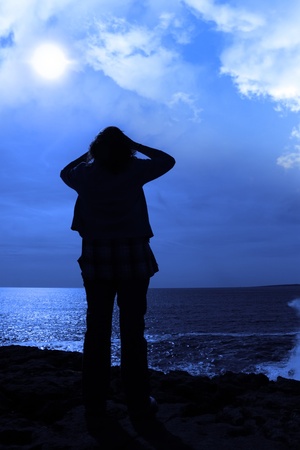a lone woman looking sadly over the cliffs edge in county clare irelandの写真素材