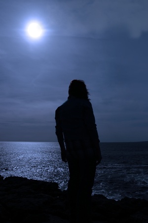 a lone woman looking sadly over the cliffs edge in county clare irelandの写真素材