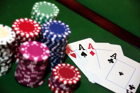 green casino table four aces in a poker game and a big pile of chipsの写真素材