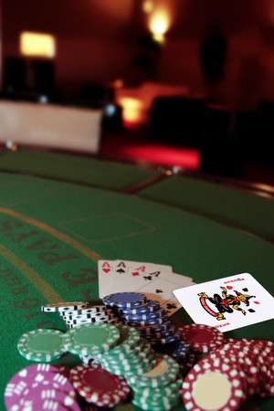 green casino table with chips and four aces in a poker game and a joker in the packのeditorial素材