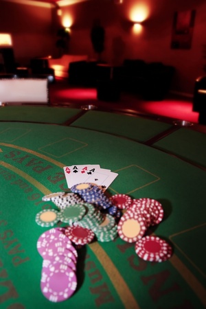 green casino table four aces in a poker game and a big pile of chipsの写真素材