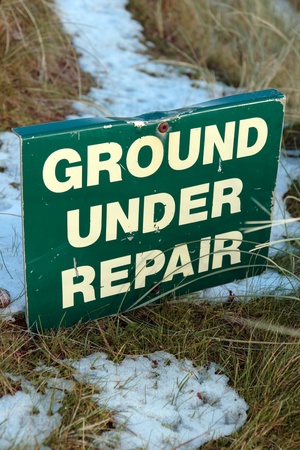 ground under repair sign on a snow covered links golf course in ireland in snowy winter weatherの写真素材