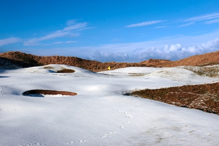 yellow flag on a snow covered links golf course in ireland in winterの写真素材