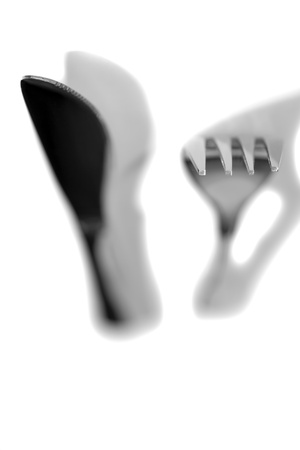 knife and fork with shadows isolated against a white backgroundの写真素材