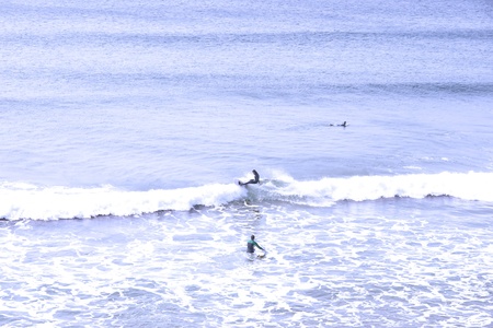 beautiful clean atlantic ocean with surfers catching the waves on Irelands coastの写真素材