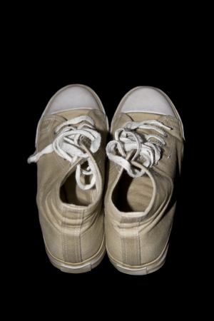 beige classic youth canvas shoes on a black background with a clipping pathの写真素材