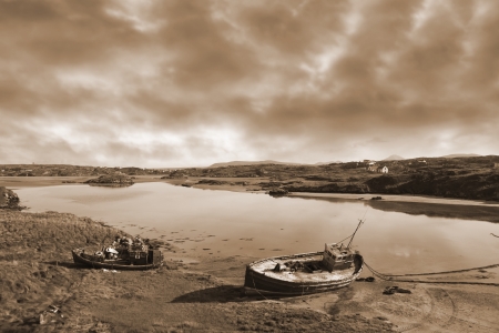 two old fishing boats beached on a coastal beach in county Donegal, Ireland in sepiaの写真素材