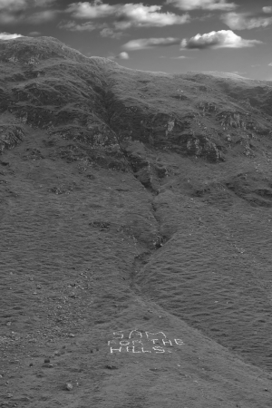Sam for the hills written with rocks on mountains in county Donegal Ireland in black and white