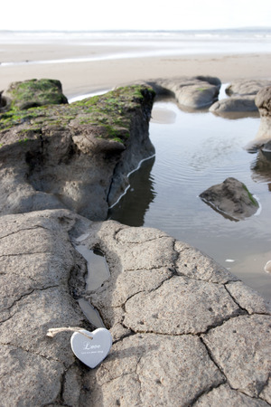 single wooden love hearts on the sand banks of an Irish beach in county Kerryの写真素材