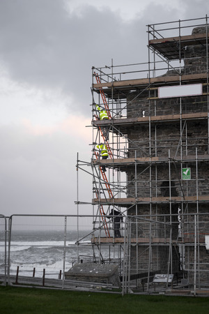 workmen repair ballybunion castle on the cliffs surrounded by scafolding while under repairのeditorial素材