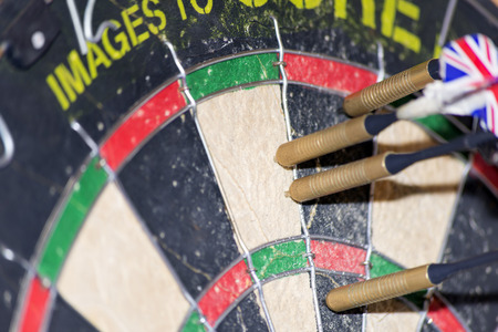 four darts in the bed of a dartboardの写真素材