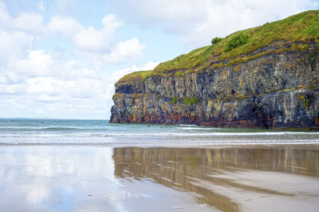 lone kayaker near the cliffs of ballybunion beach on the wild atlantic way irelandの写真素材