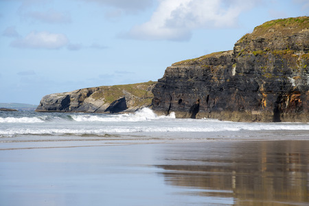 beautiful soft waves break on the beach cliffs at ballybunionの写真素材