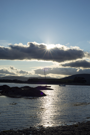 boats in a quiet bay near kenmare on the wild atlantic way ireland with a cold sunsetの写真素材