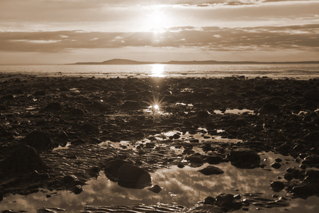 reflections at rocky beal beach near ballybunion on the wild atlantic way ireland with a beautiful yellow sunsetの写真素材
