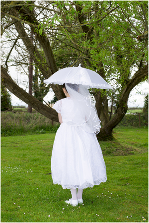 young irish girl in her communion dress with a white umbrellaの写真素材