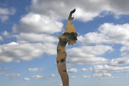 see through silhouetted nude woman holding her hands up to the sky giving gratitude to the heavens in a yoga pose with a cloudy backgroundの写真素材