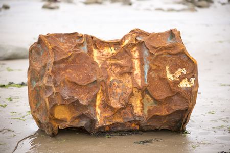 rusty metal barrel washed up on the beachの写真素材