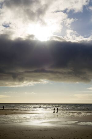 silhouette of people walking on ballybunion beachの写真素材