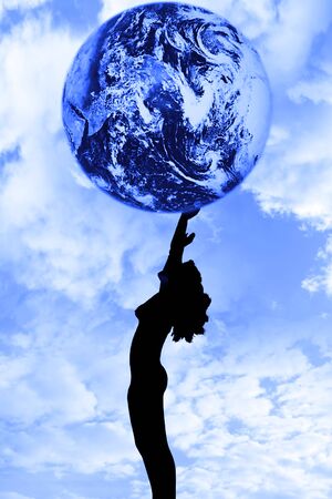 attractive silhouetted nude woman holding the earth giving gratitude to the heavens in a yoga pose with a cloudy backgroundの写真素材
