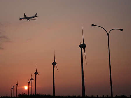 Combination of airplane landing and sunsetの写真素材