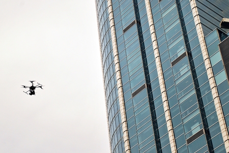 Drone silhouette flying above cityの写真素材