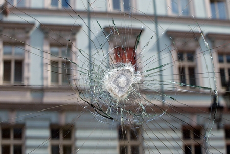 Broken window with a bullet hole in the middle