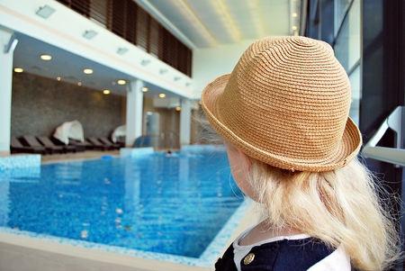 Little girl near swimming pool. Toddler girl in the pool looking sidewaysのeditorial素材
